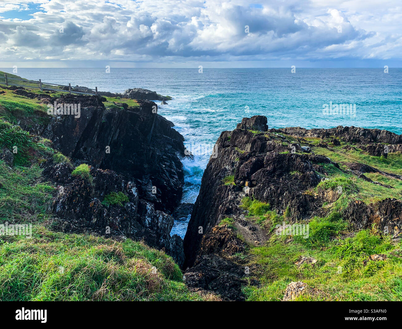 Blaue und grüne Seascape, eine Lücke in der herrlich grünen bedeckten Landzunge, die zum blauen Pazifik und Horizont führt Stockfoto