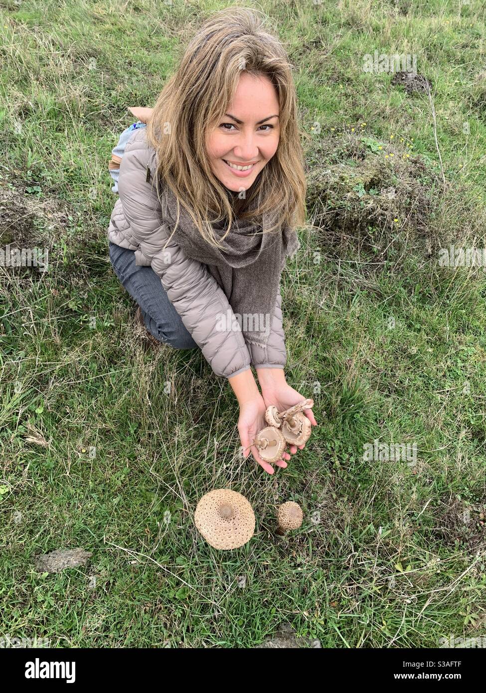 Frau, die in Staines Moor zottelige Parasolpilze pflüpft Stockfoto