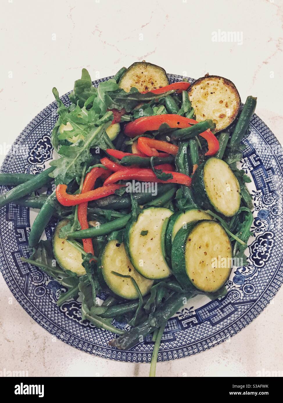 Sautierte gesundes grünes Gemüse in einer hübschen blauen Weidenschale. Stockfoto