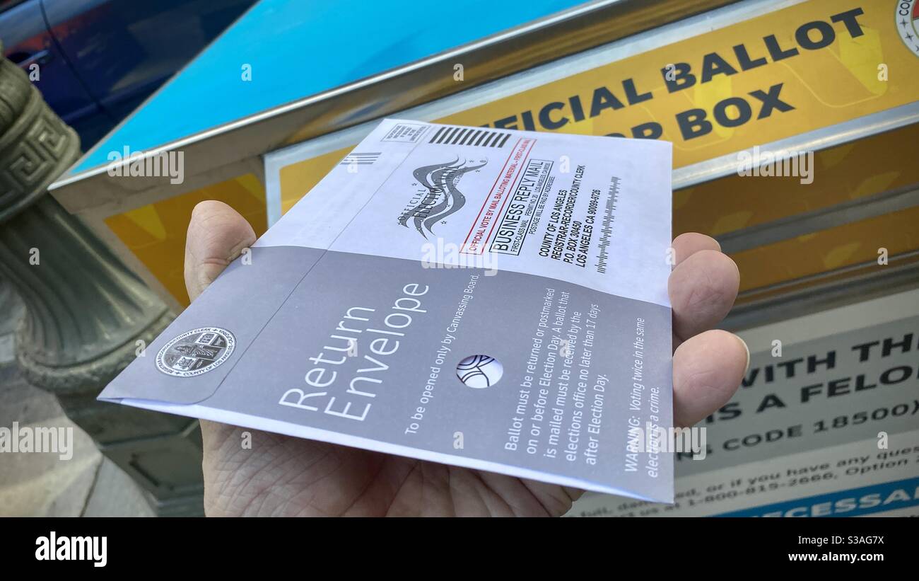 LOS ANGELES, CA, OCT 2020: Hand mit 2020 US-Präsidentschaftswahlen Wahlformular im Rückumschlag, über eine offizielle Wahlurne in der Innenstadt hinterlegt werden - Smartphone-aufgenommenes Stockfoto