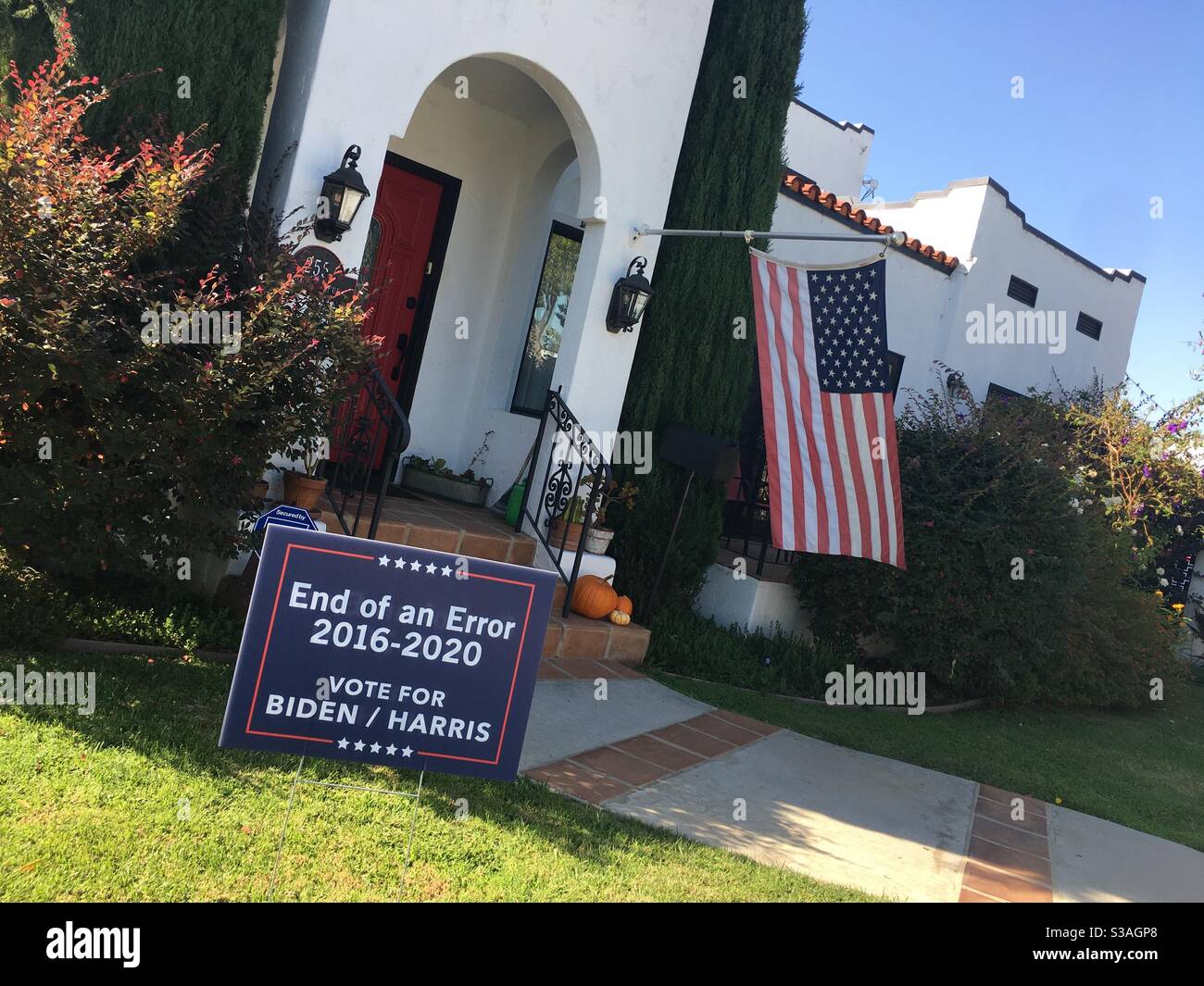 Ein Schild mit der Aufschrift „End of an Error, 2016-2020, Vote for Biden/Harris“ vor einem Haus mit amerikanischer Flagge in Long Beach, Kalifornien - Smartphone-aufgenommenes Stockfoto