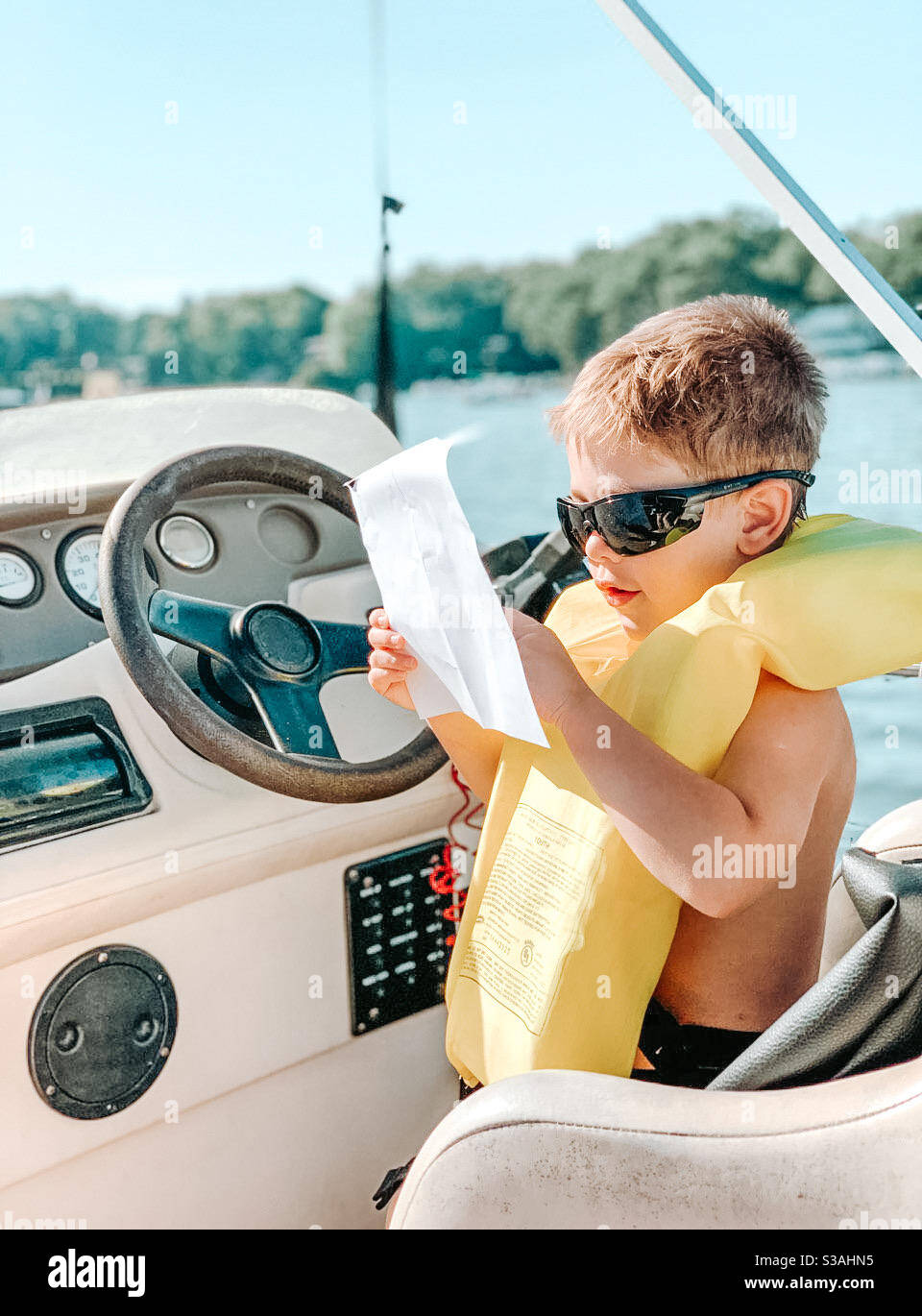Junge fahren ein Boot draußen auf einem See auf einem Sonniger Tag Stockfoto