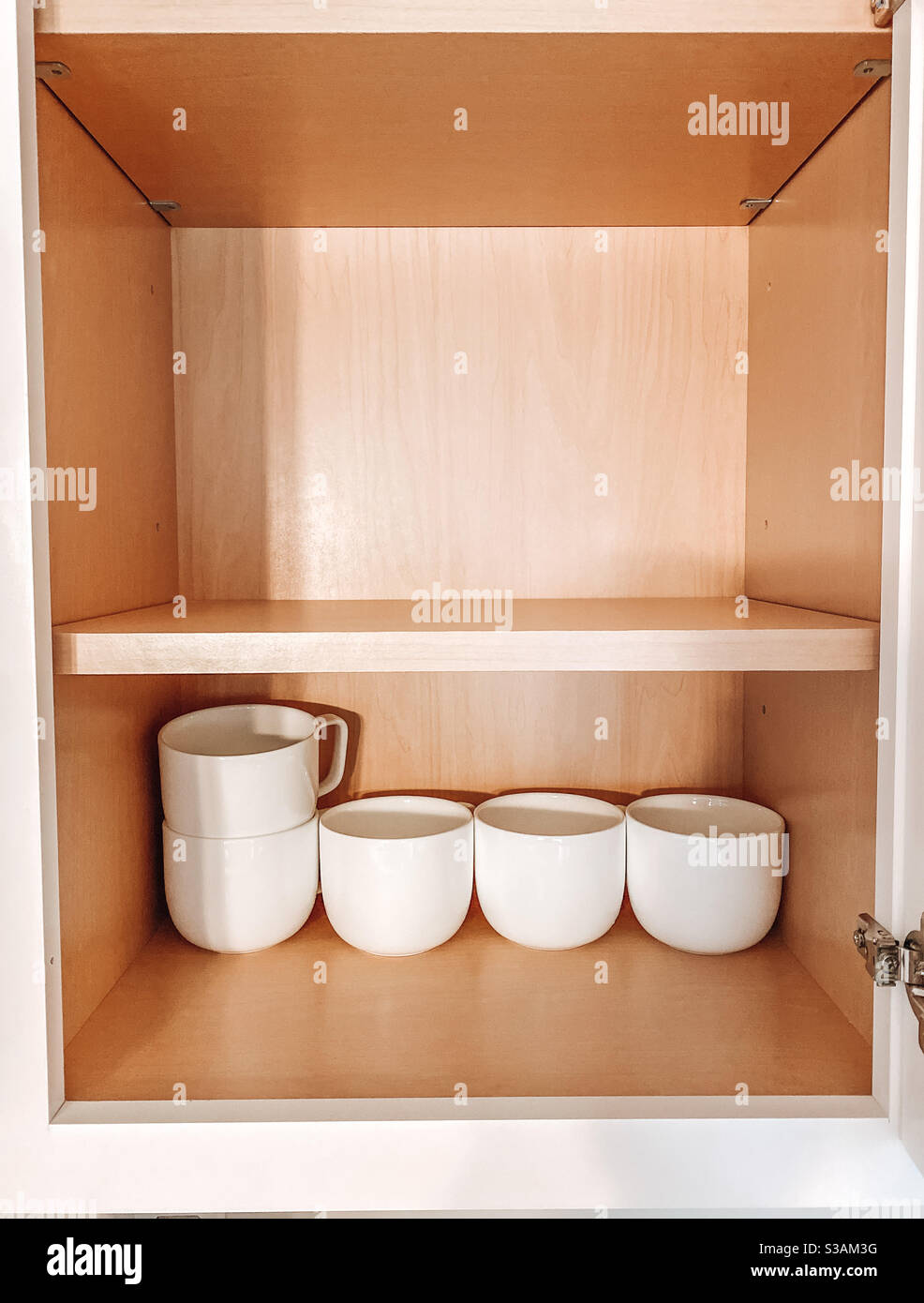 Küchenschrank mit einer Reihe von Tee- und Kaffeetassen Als eine neue Familie einzieht Stockfoto