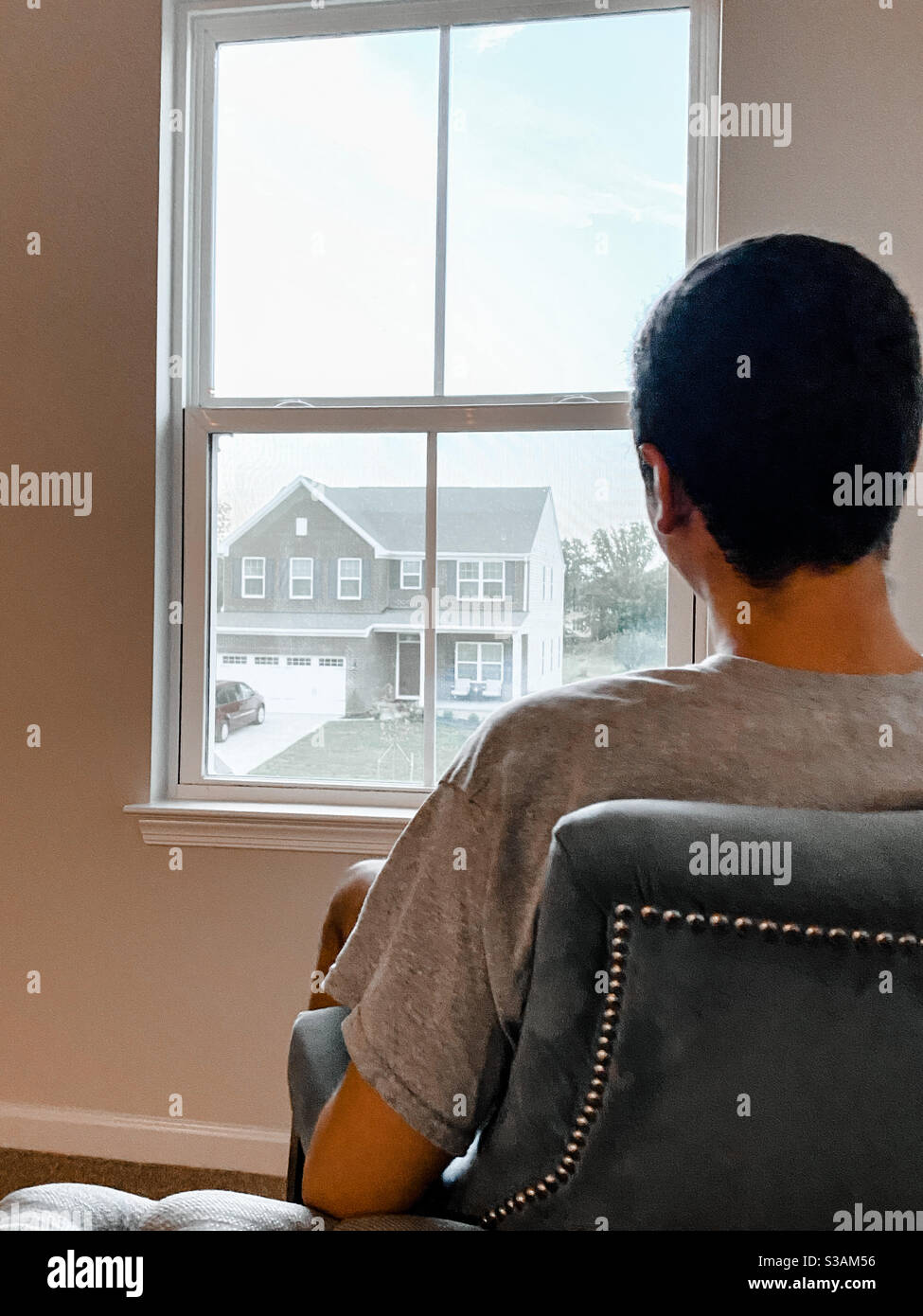 Junger Mann, der beim Träumen aus dem Fenster schaut Stockfoto