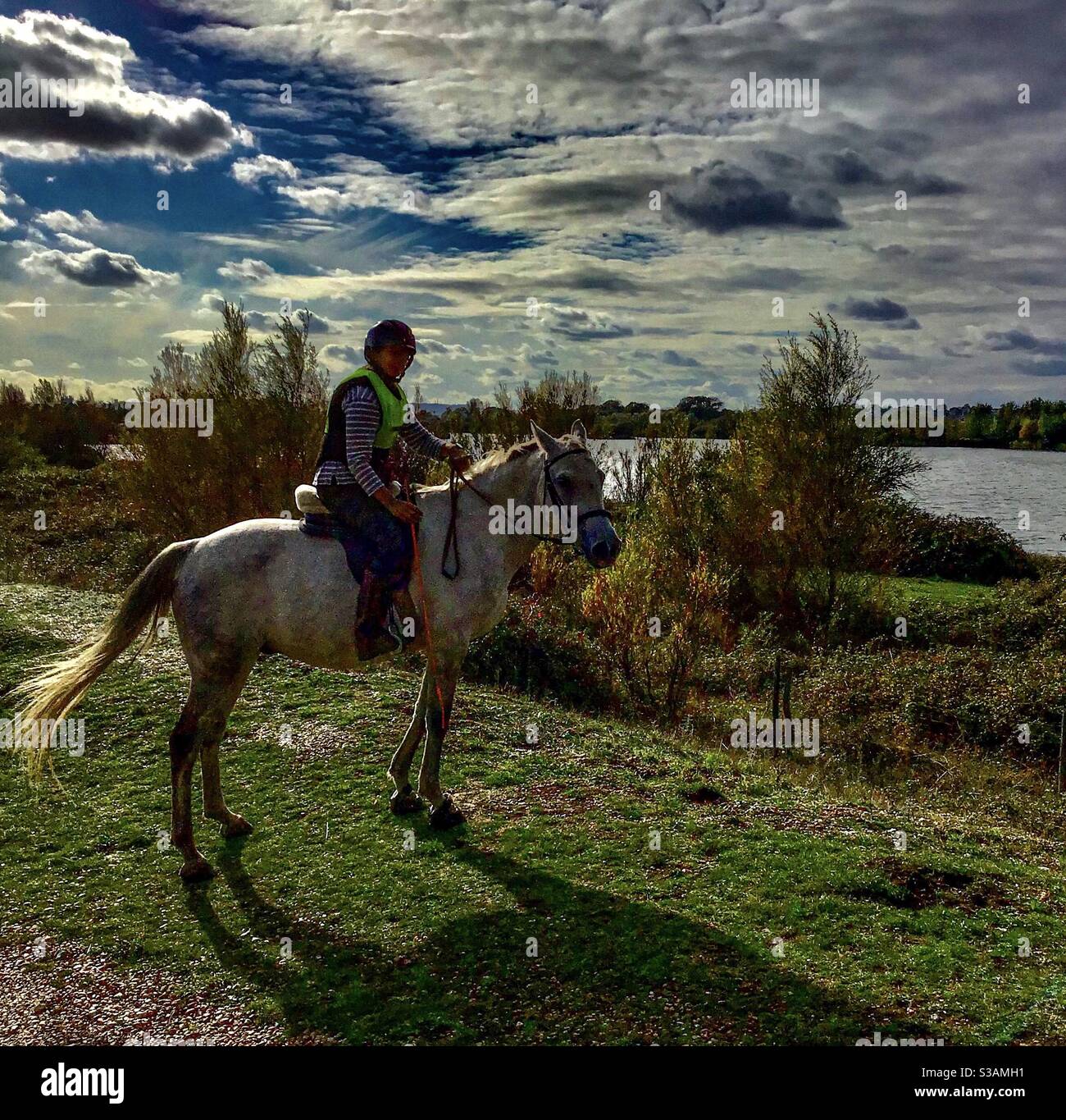 Lady Horse Rider am See Stockfoto