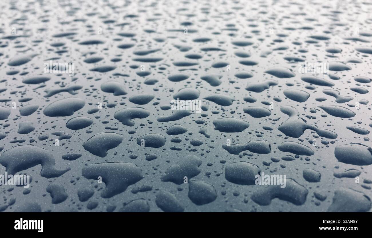 Regentropfen auf glänzender schwarzer wasserabweisender Oberfläche abstrakter Hintergrund - Smartphone-aufgenommenes Stockfoto