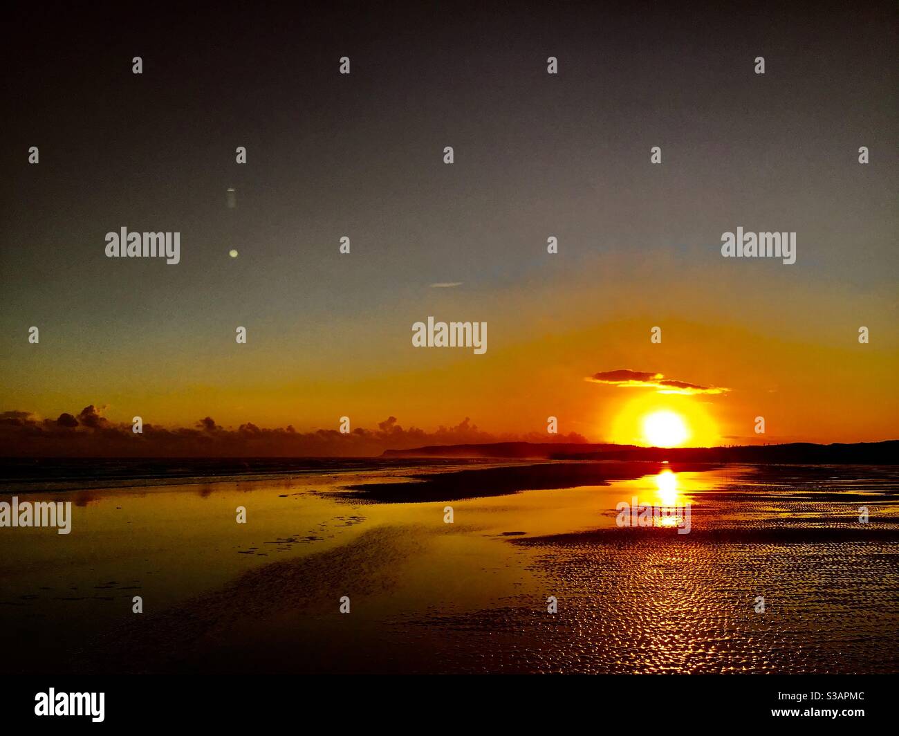 Sonnenuntergang bei Ebbe Stockfoto