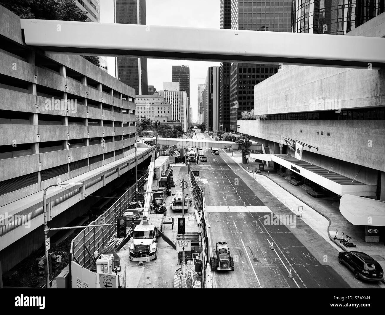 LOS ANGELES, CA, JUL 2020: Blick nach Süden entlang der Flower Street, mit LA Metro Neubau im Vordergrund. Parkplatz Struktur auf der linken Seite und Fußgängerbrücken überqueren die Straße. Schwarz und Weiß Stockfoto