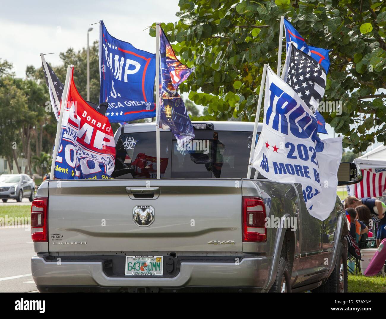 Pickup truck flying multiple Trump flags, illustrating the pageantry and spectacle dimension of strongman politics.