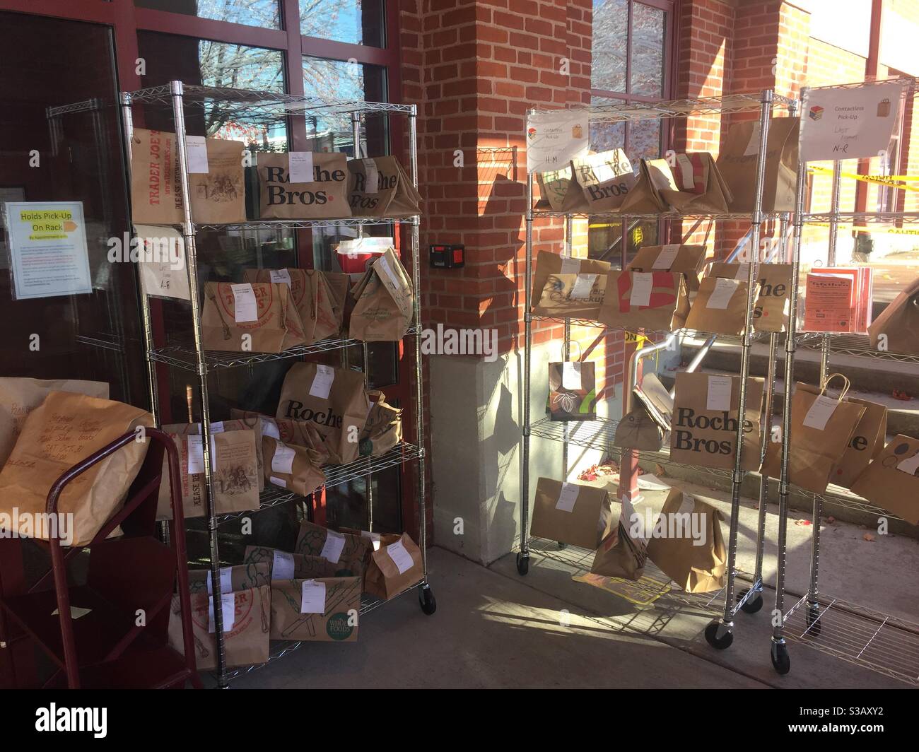 Bücherregale halten während einer Pandemie Bücheranfragen von Gästen in Papiertüten. Berührungslose Buchabholung bei Goodnow Library in Sudbury, Massachusetts, 31. Oktober 2020. Stockfoto