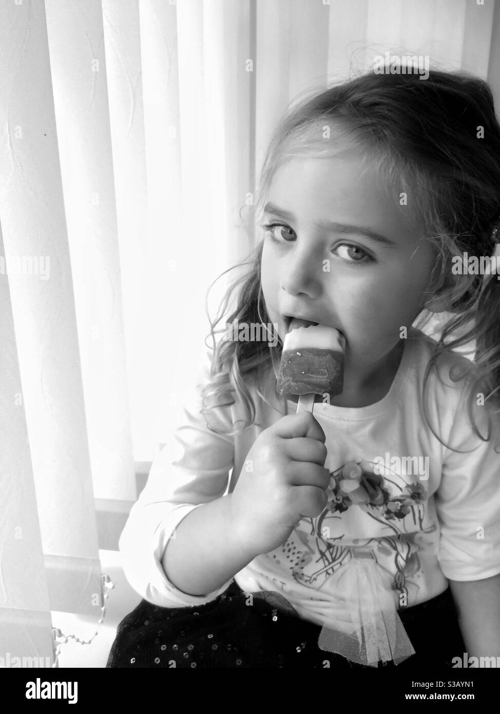 Junges Mädchen genießen ein Eis Lolly. Stockfoto
