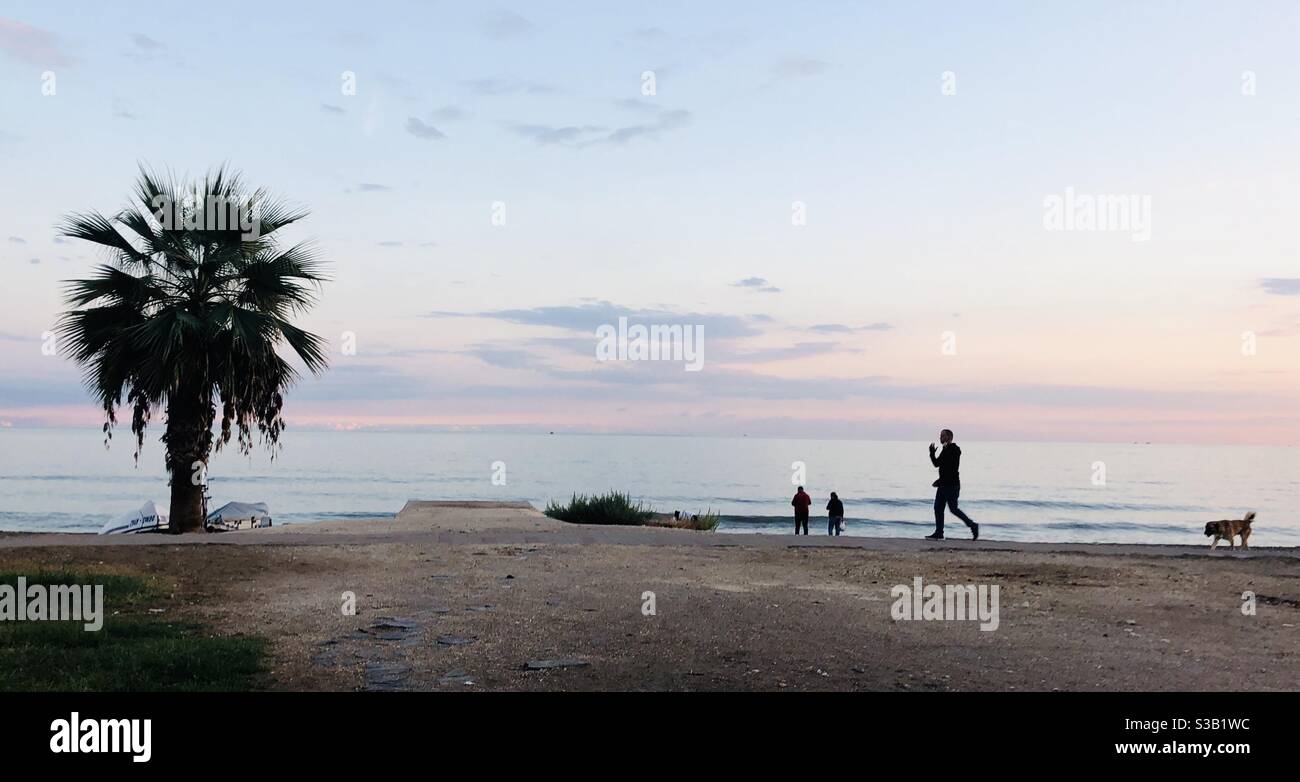 Silhouette von Menschen, die am Strand sind - Smartphone-aufgenommenes Stockfoto