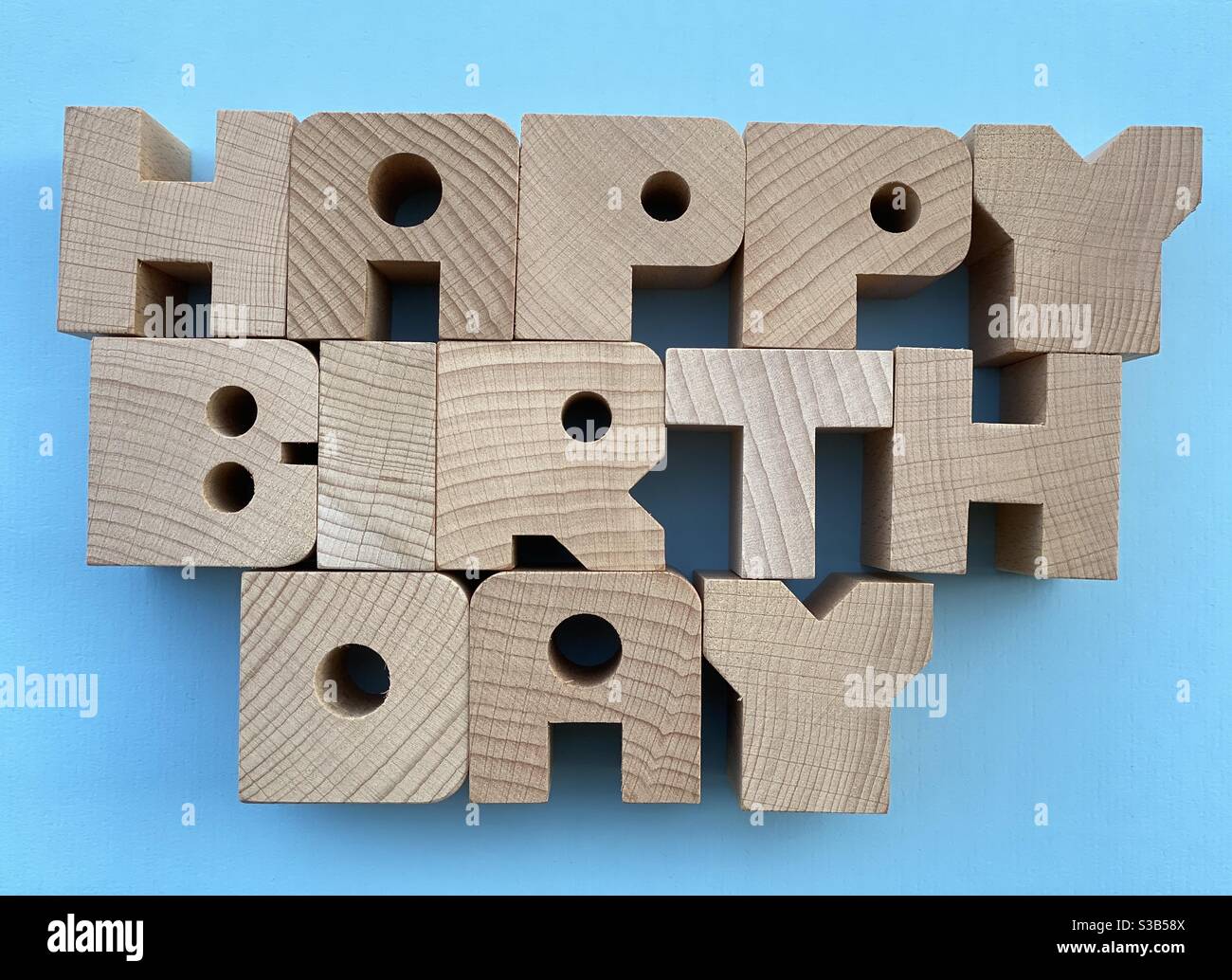 Happy Birthday Text mit Holzbuchstaben auf blauem Hintergrund Stockfoto