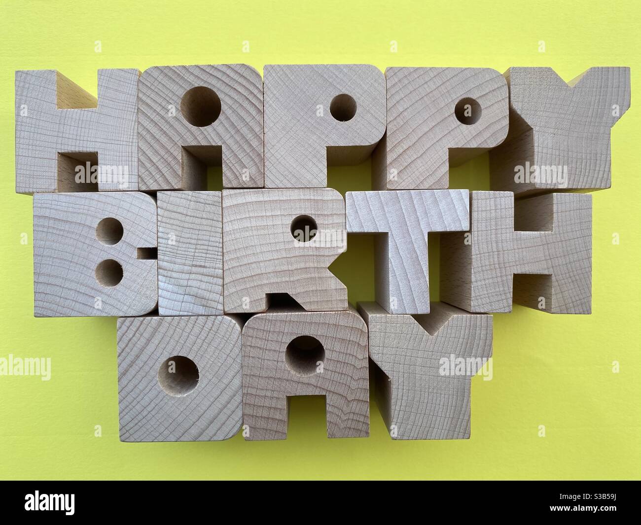 Happy Birthday Text mit Holzbuchstaben auf gelbem Hintergrund Stockfoto