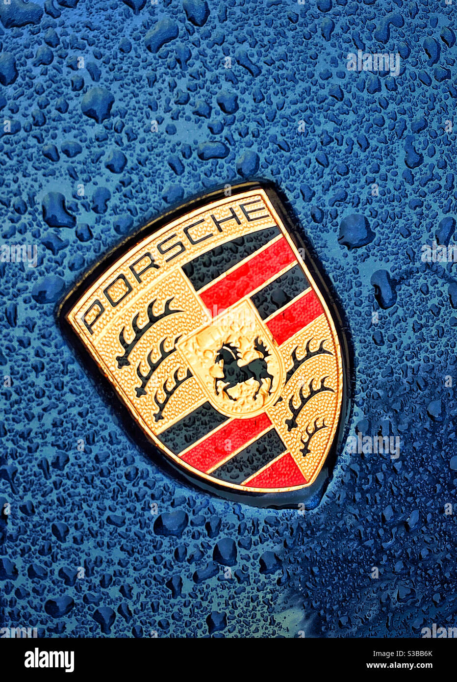 Das ikonische „Porsche“-Abzeichen/Logo, das mit Regentropfen bedeckt ist. Keine Personen, Platz für Text/Text. Bildnachweis - ©️ COLIN HOSKINS. - Smartphone-aufgenommenes Stockfoto