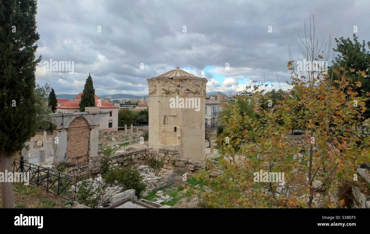 Der Turm der Winde, eine alte Wetterfahne und ein Uhrturm, steht inmitten der Ruinen der römischen Agora in Athen, Griechenland, unter einem bewölkten Himmel Stockfoto