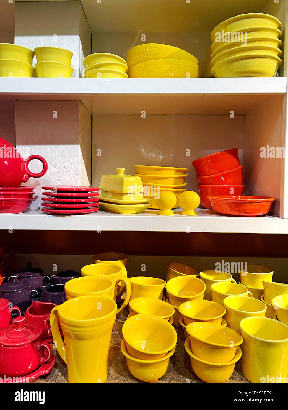 Rote, gelbe und orangefarbene Keramikschalen im Laden Stockfoto