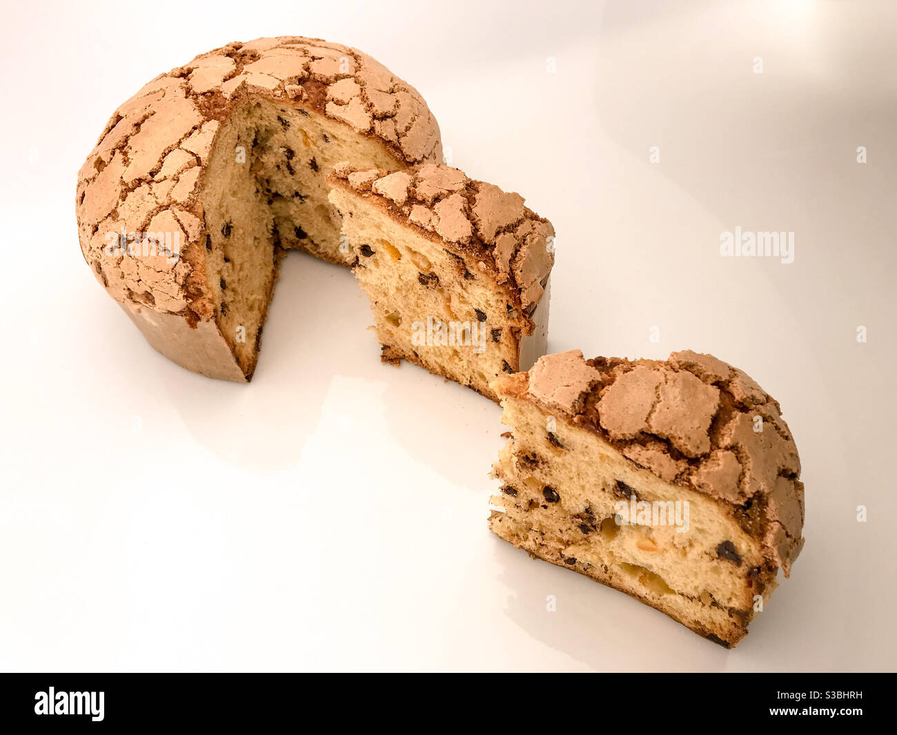 Panettone, klassische Weihnachten Mailand Dessert mit Rosinen und Schokolade, Kuchen in Scheiben geschnitten mit zwei Scheiben isoliert auf weiß - Smartphone-aufgenommenes Stockfoto