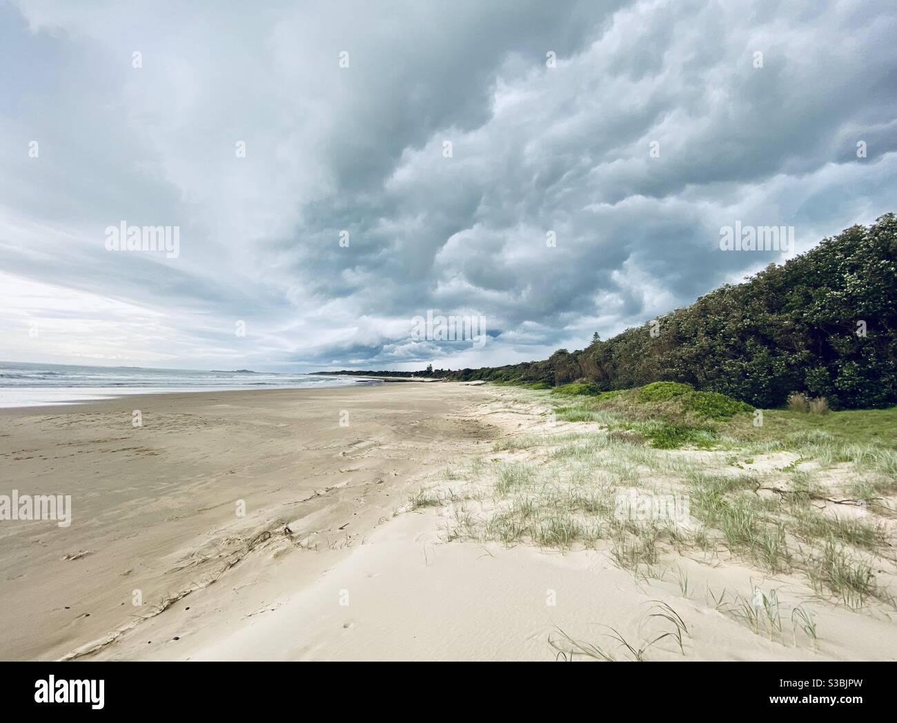Isolierter Strand mit turbulenten Wolken einer Sturmfront nähert sich Stockfoto