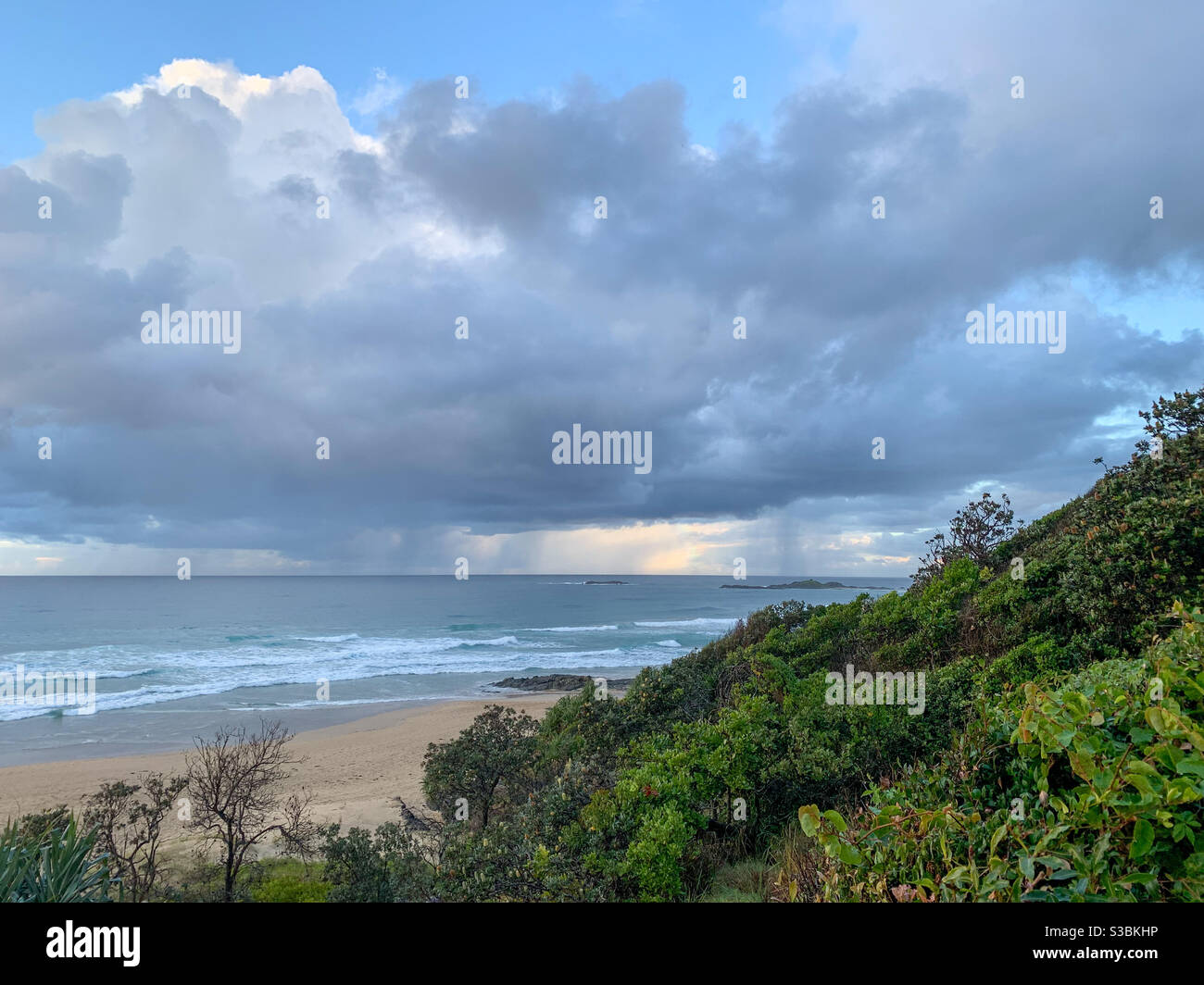 Wenn man an der Landzunge vorbeischaut, kann man sehen, wie der Regen fällt Auf dem Meer Stockfoto