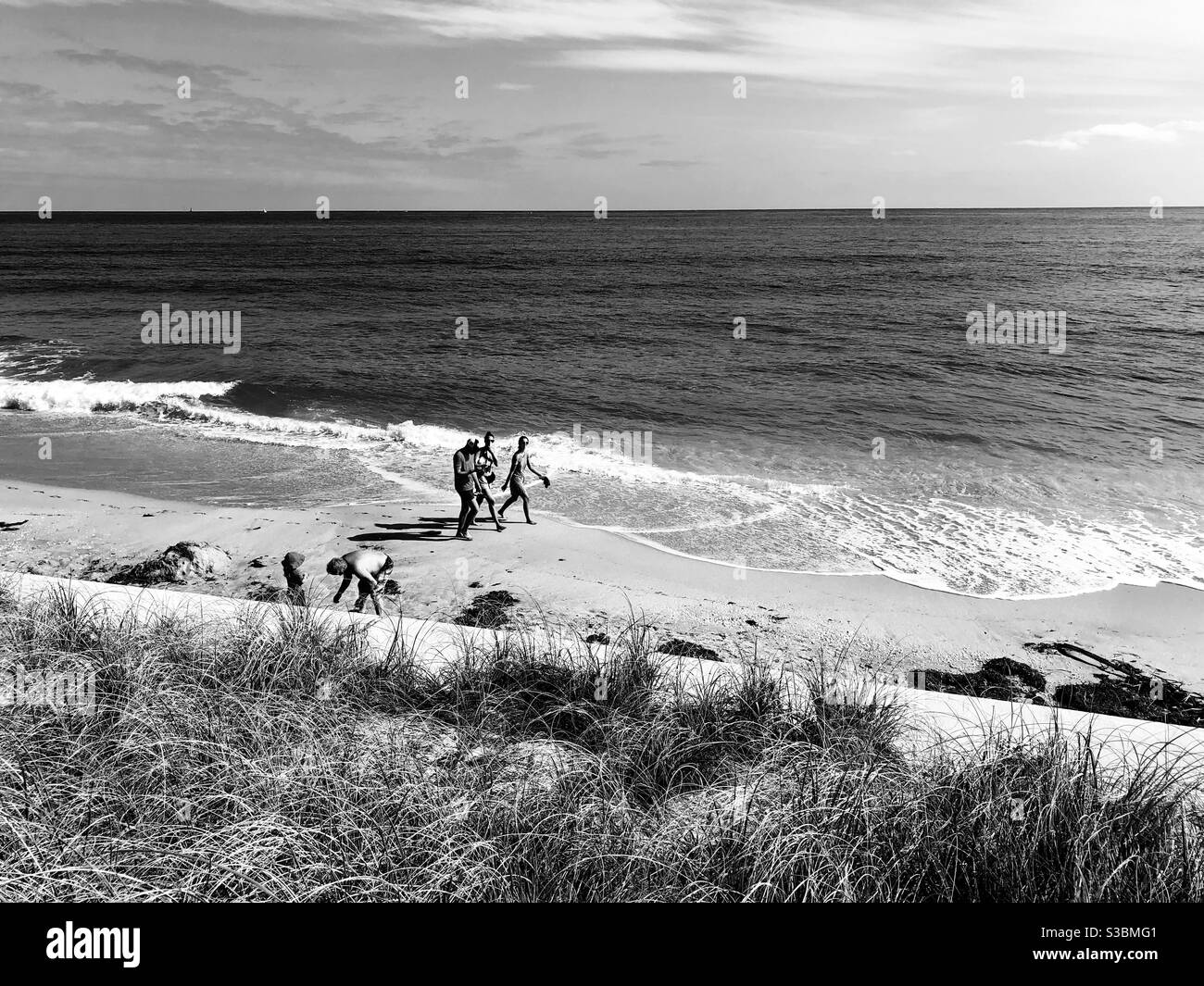 Strandszene in schwarz und weiß mit Menschen am Meer, Lantana, Florida. - Smartphone-aufgenommenes Stockfoto