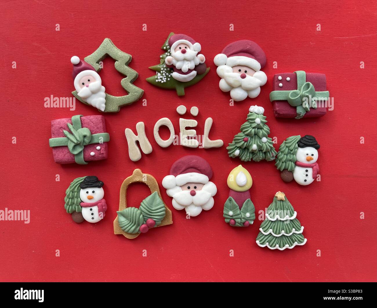 Noël, französisch Weihnachten mit Holzbuchstaben und Marzipan Weihnachten Symbole auf rotem Hintergrund Stockfoto