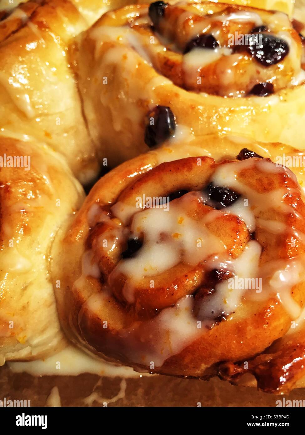 Eine Nahaufnahme von goldbraunen klebrig glasierten Chelsea-Brötchen Stockfoto