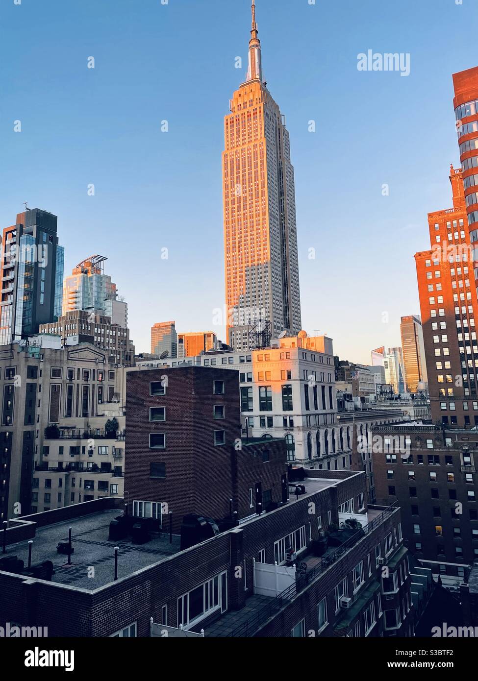 Sonnenaufgang in der City von New York, wenn es langsam beleuchtet Gebäude wie das Empire State Building in Midtown Manhattan. Stockfoto