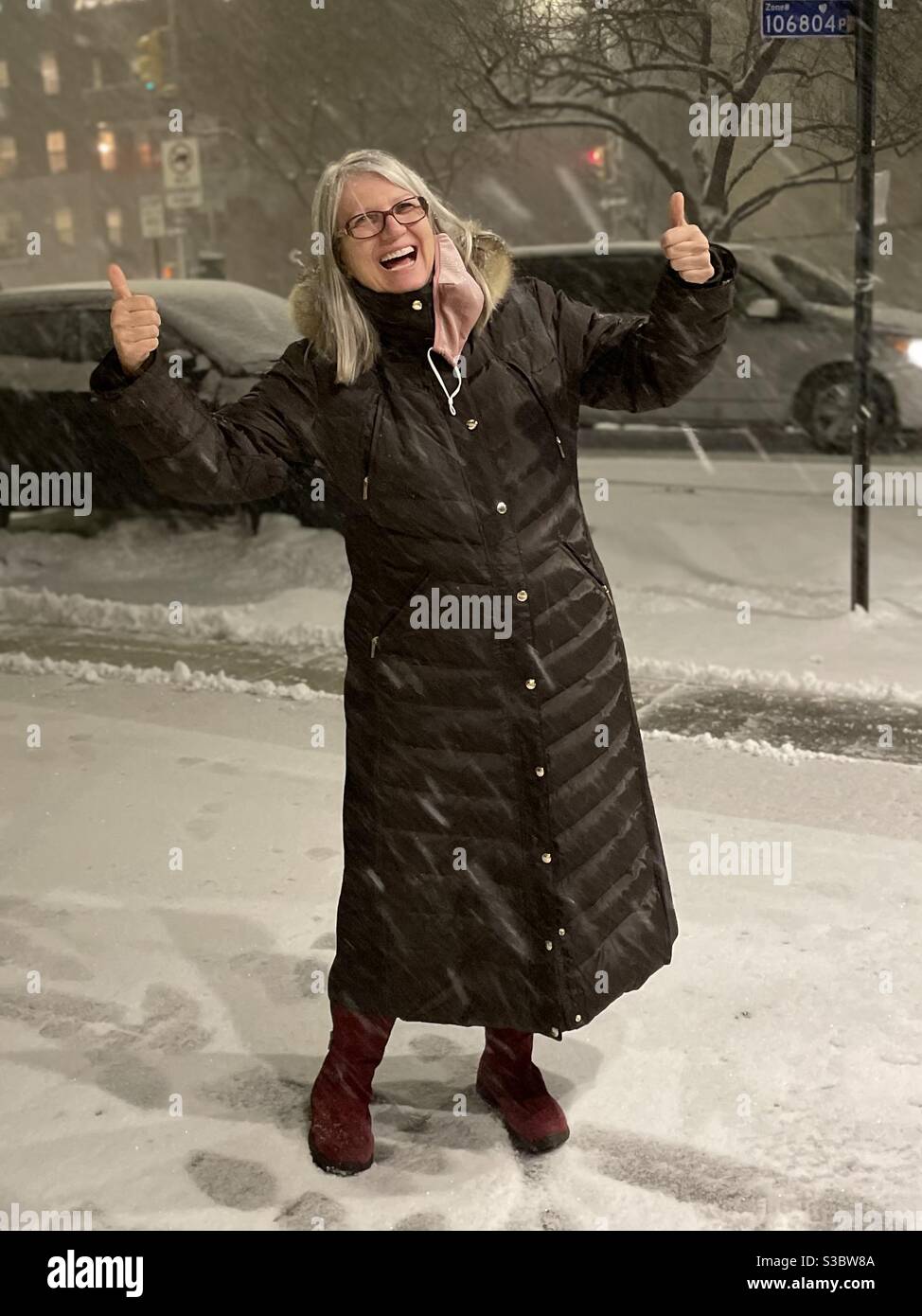 Es ist Schnee Zeit!! Frau freute sich über den ersten großen Schnee der Saison in Manhattan. - Smartphone-aufgenommenes Stockfoto