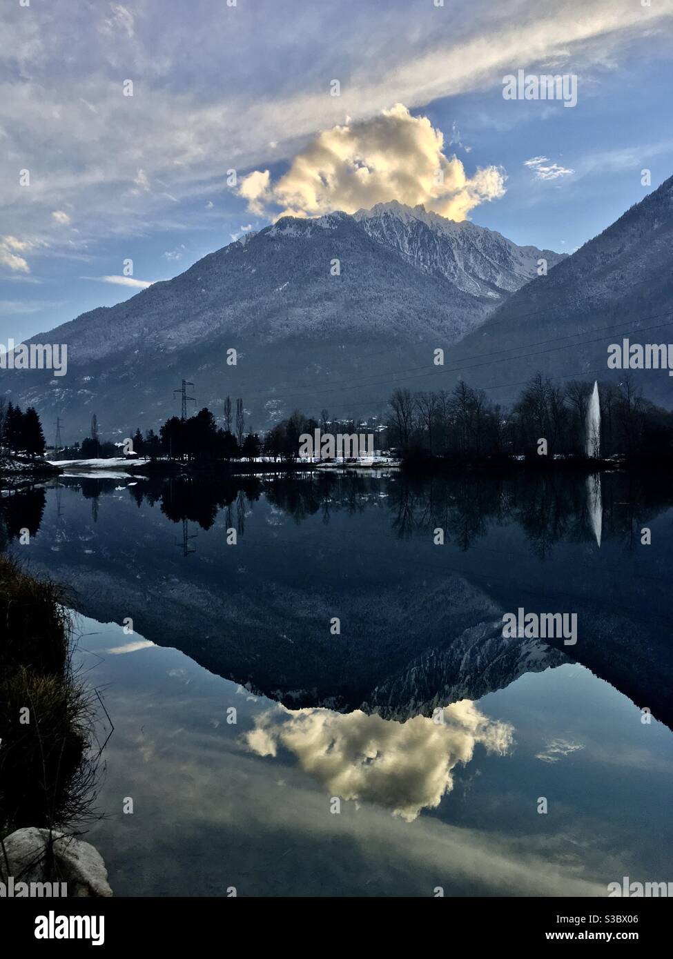 Reflets de la montagne dans Le Lac bleu de Saint-Rémy-de-Maurienne En Savoie un soir d’hiver Stockfoto