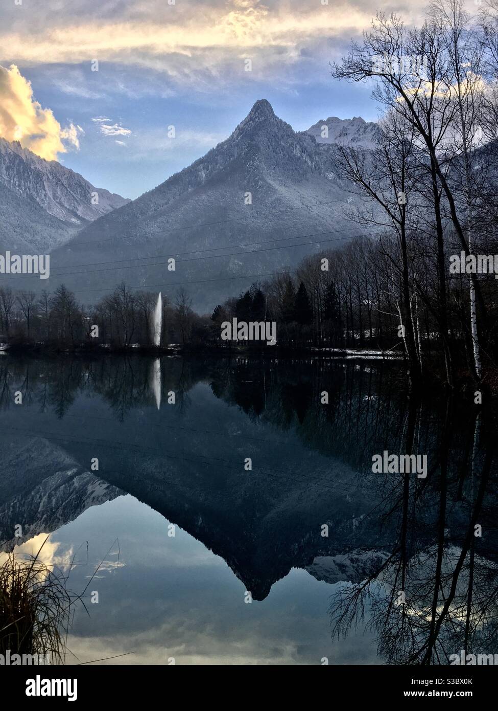 Reflets de la montagne mauriennaise dans le Lac Bleu de la base de loisirs de Saint-Rémy-de-Maurienne en Savoie un soir d’hiver Stockfoto