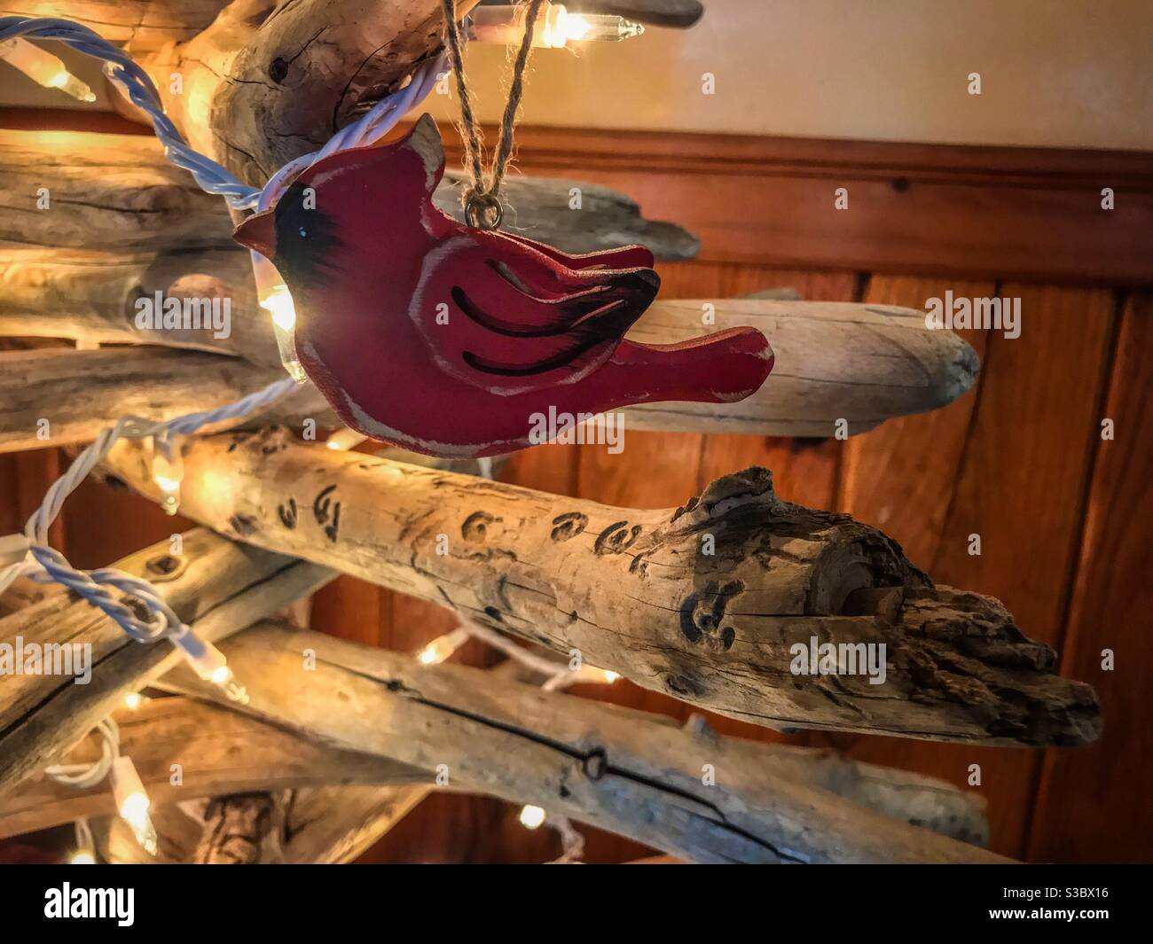 Driftwood Weihnachtsbaum mit rotem Vogel und weißen Lichtern Stockfoto