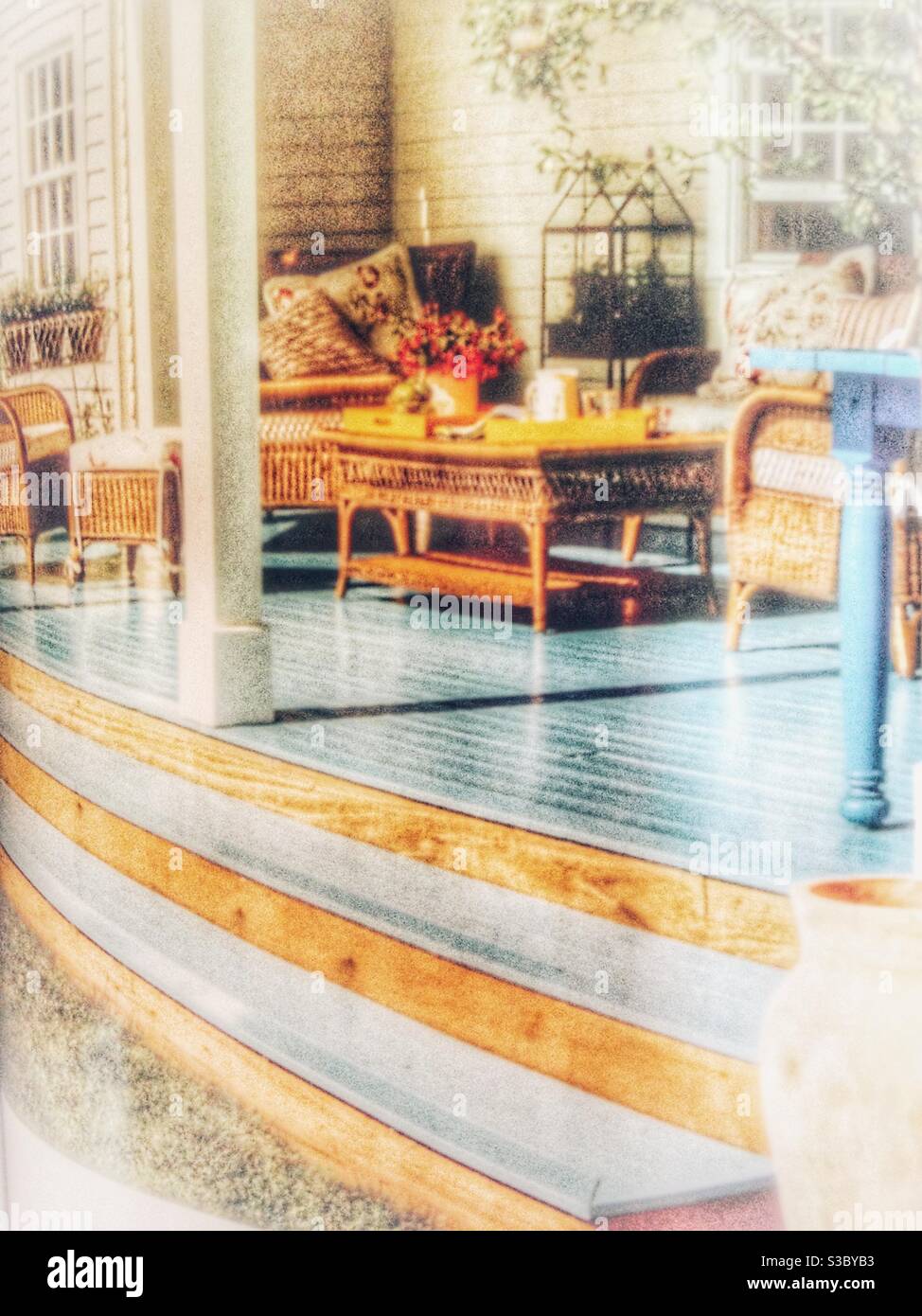 Lust auf eine gemütliche Veranda oder Veranda? Diese verträumte Vignette könnte in Kalifornien (es ist) oder Georgia sein. Korbmöbel & Vintage-Touch sprechen Hausjäger an, die sich in der Sonne entspannen wollen. - Smartphone-aufgenommenes Stockfoto