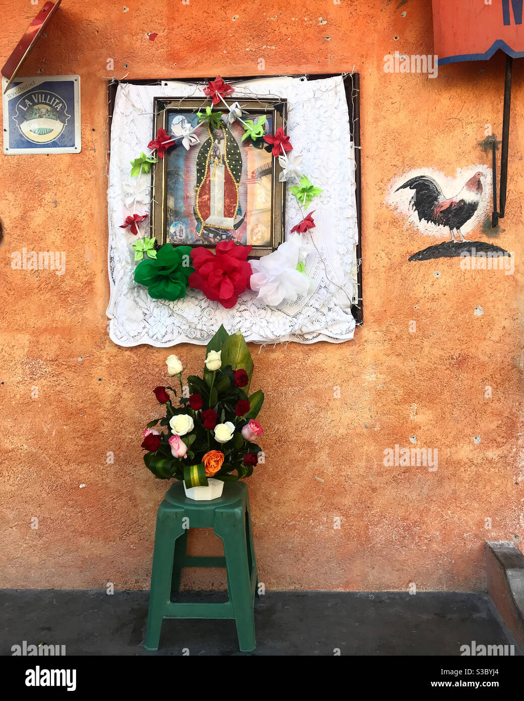 Blumen schmücken einen Altar unserer Lieben Frau von Guadalupe in Peña de Bernal, Queretaro, Mexiko Stockfoto