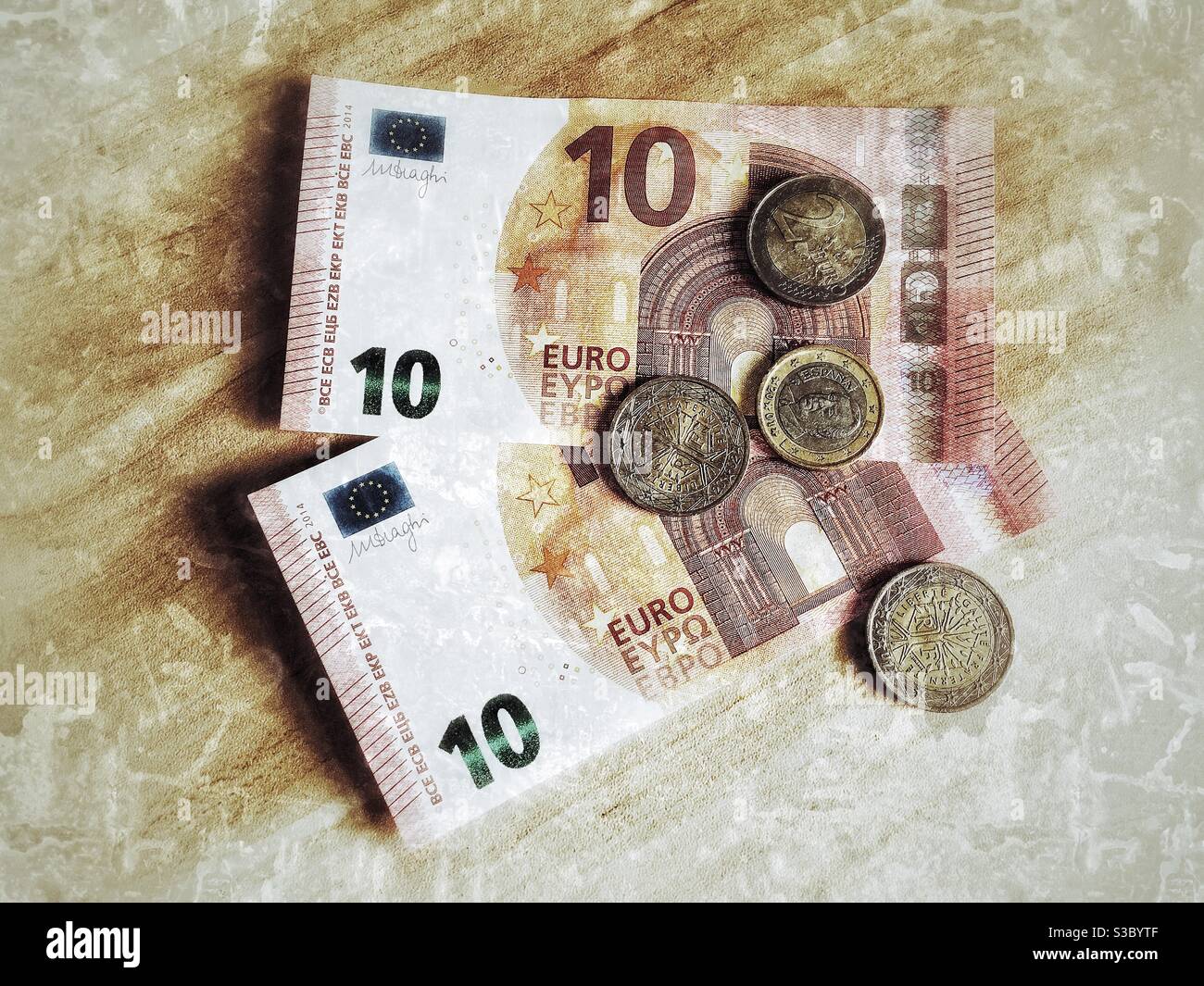 Euro-Banknoten und Euro-Münzen auf einem Holzschreibtisch. - Smartphone-aufgenommenes Stockfoto