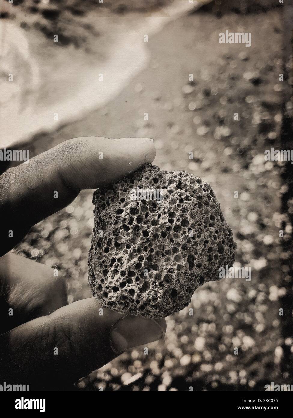 Zen-Bild von einem strukturierten Stein am Strand gefunden - Smartphone-aufgenommenes Stockfoto