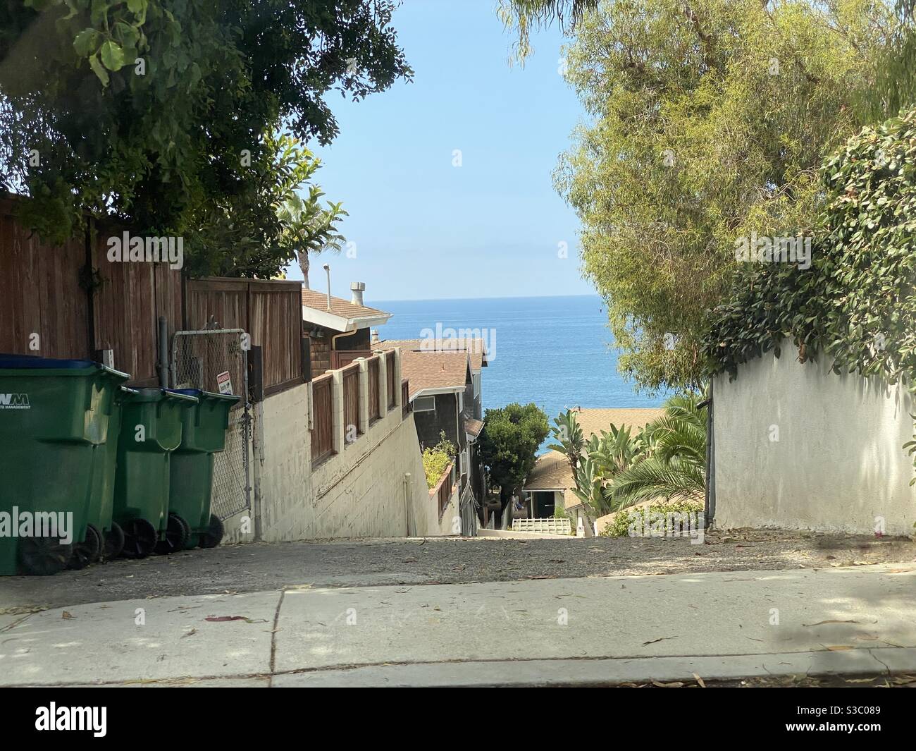 Blick auf eine steile Gasse hinter Strandgrundstücken mit Blick auf den Pazifik in Laguna Beach, Kalifornien - Smartphone-aufgenommenes Stockfoto