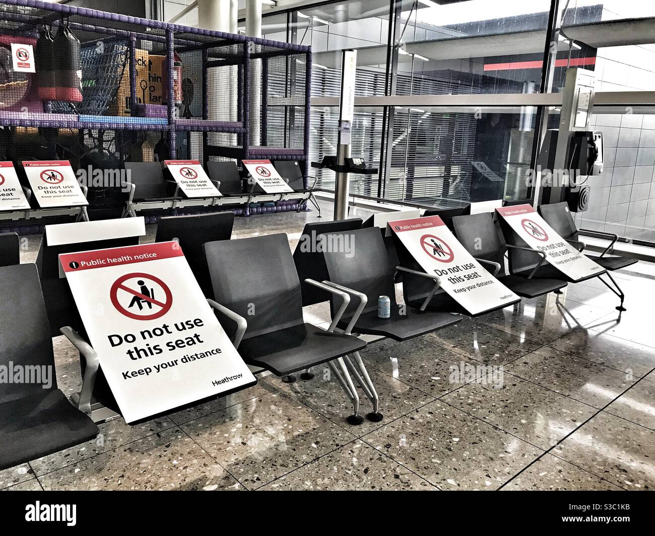Heathrow Airport T2 - gesellschaftlich distanzierte Sitzplätze aufgrund von COVID-19 - Smartphone-aufgenommenes Stockfoto