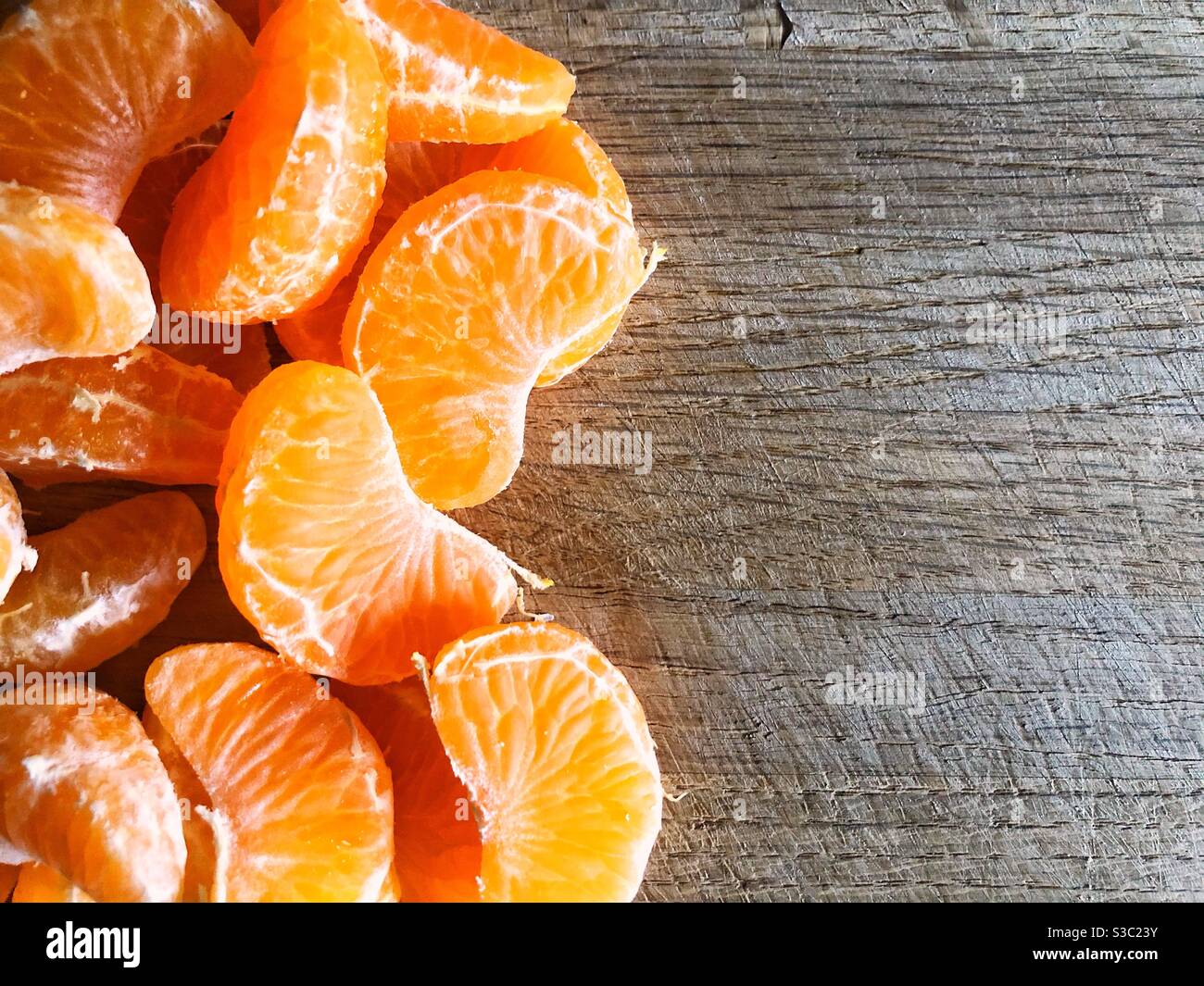 Geschälte satsuma, Orange, Clementine oder Mandarine auf einem hölzernen Hintergrund mit Kopierraum Stockfoto