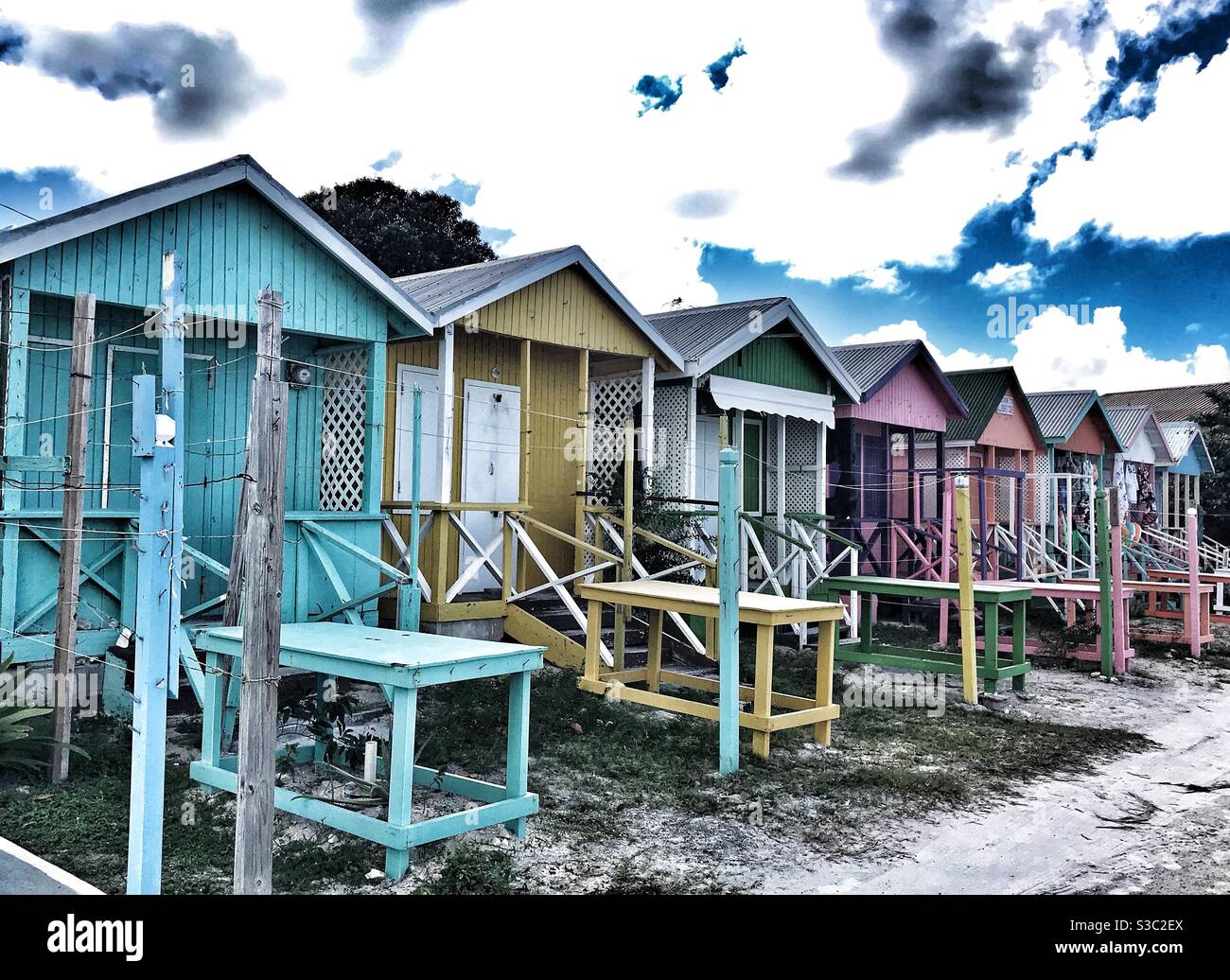 Reihe von hell bemalten Strandhütten für Verkäufer zu verkaufen Von Long Bay Beach in Antigua Stockfoto