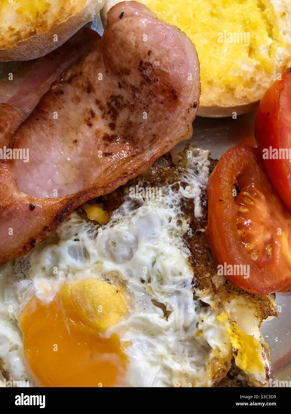 Speck und Eier mit Tomaten und geröstetem Brot Stockfoto