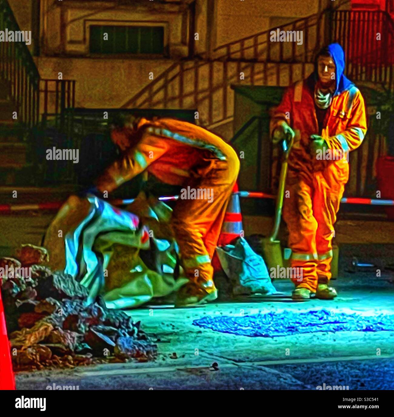 Arbeiter reparieren eine Straße in einer kalten Winternacht in New York City. - Smartphone-aufgenommenes Stockfoto