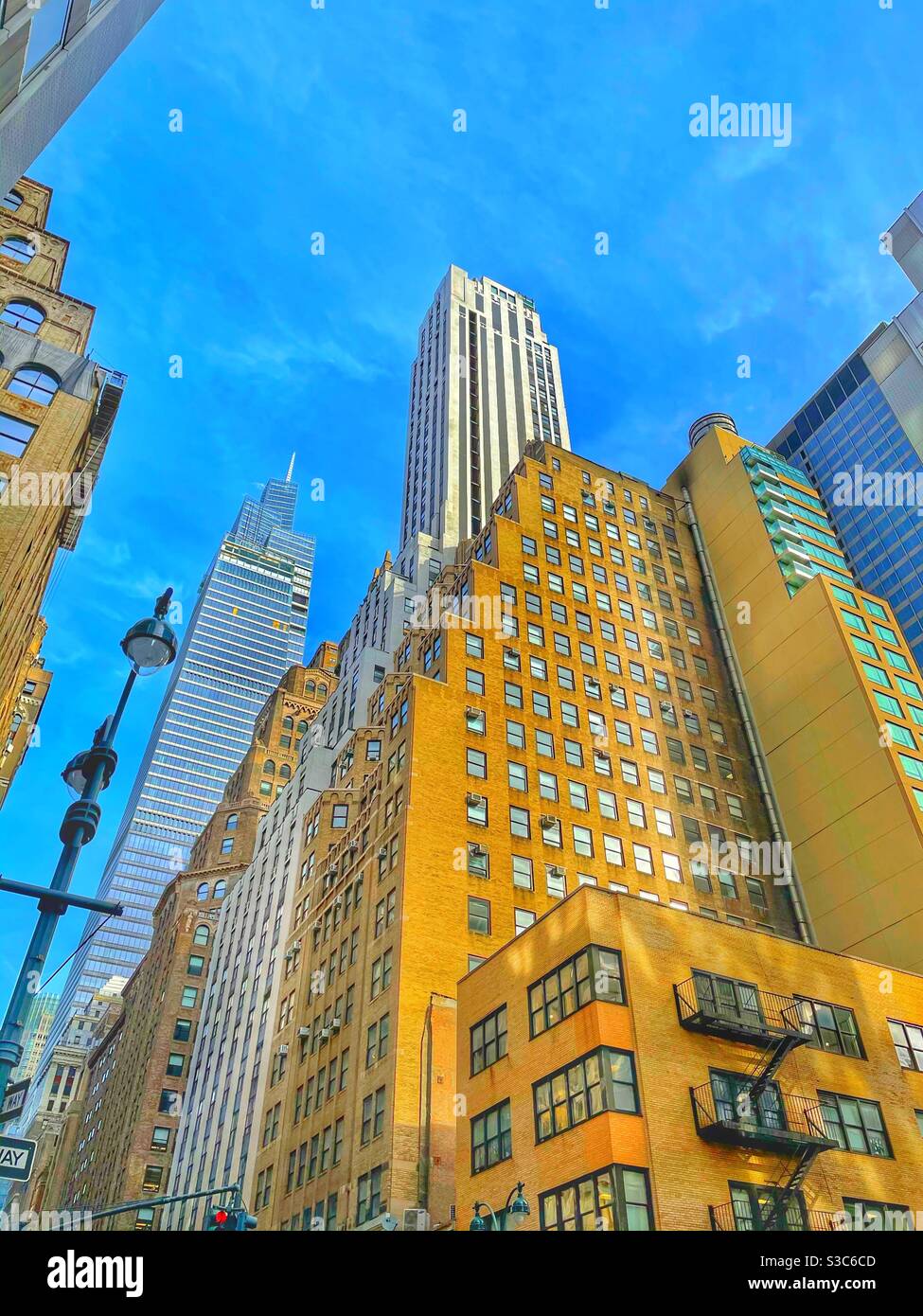 Ein schillernder Kontrast zwischen flachen Hochhäusern und Wolkenkratzern in Midtown Manhattan, New York City, USA, von der Madison Avenue aus gesehen Stockfoto