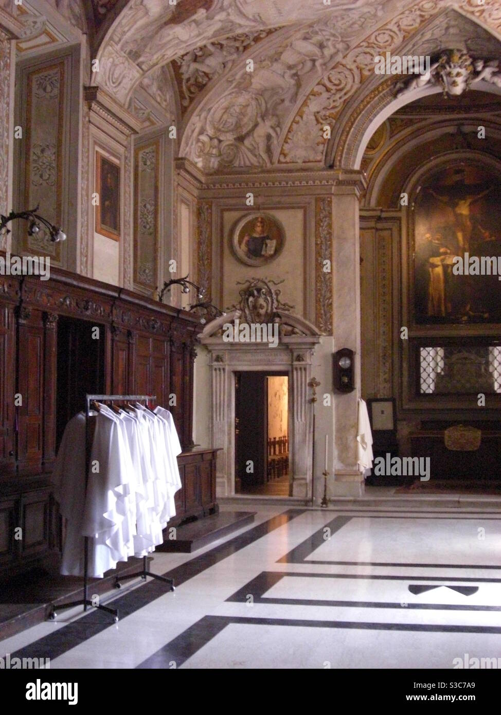 Katholische Priestergewänder hängen an der Schiene in einem prächtigen und opulenten Kathedralenraum in Rom Italien. Stockfoto
