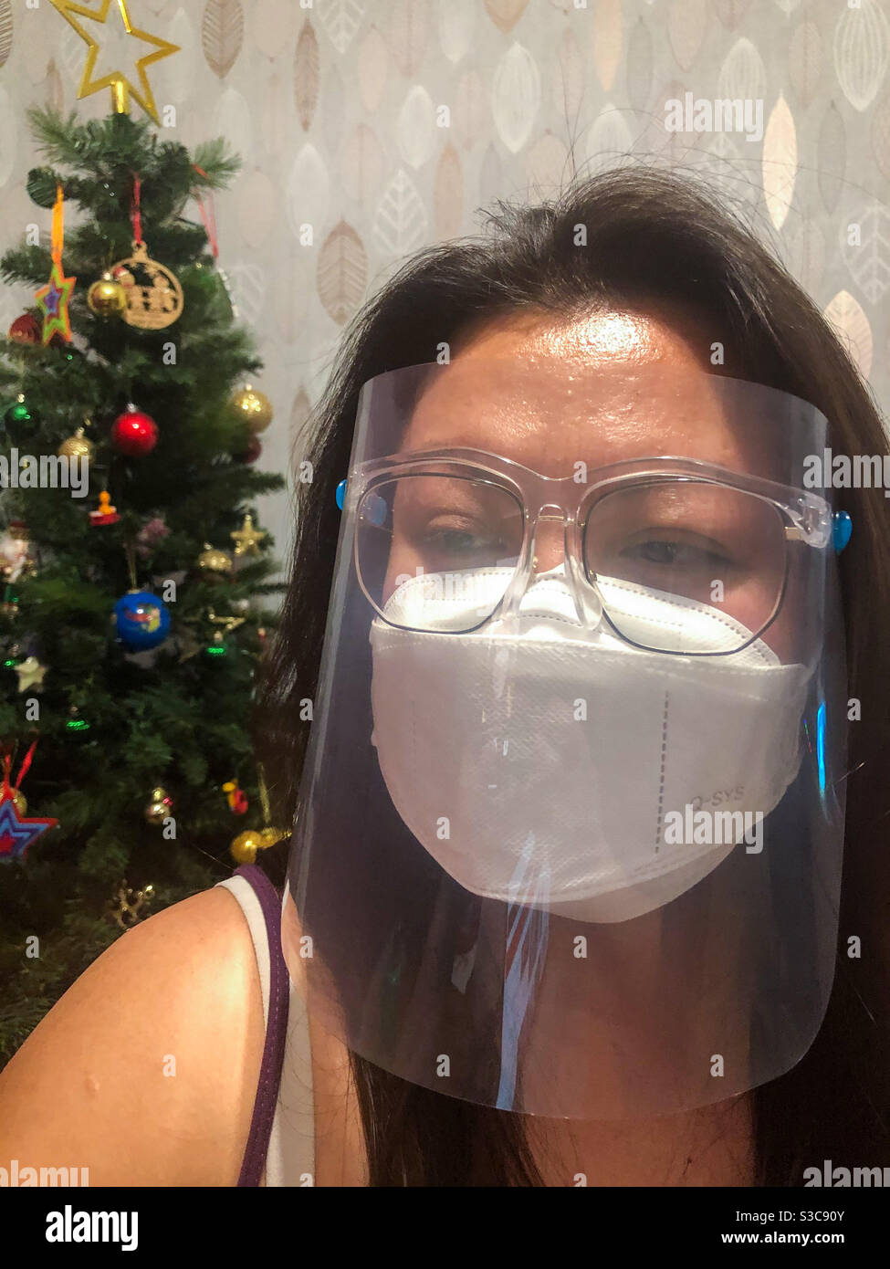 Eine Frau mit Gesichtsmaske und Gesichtsschutz als Schutz gegen Coronavirus. Stockfoto