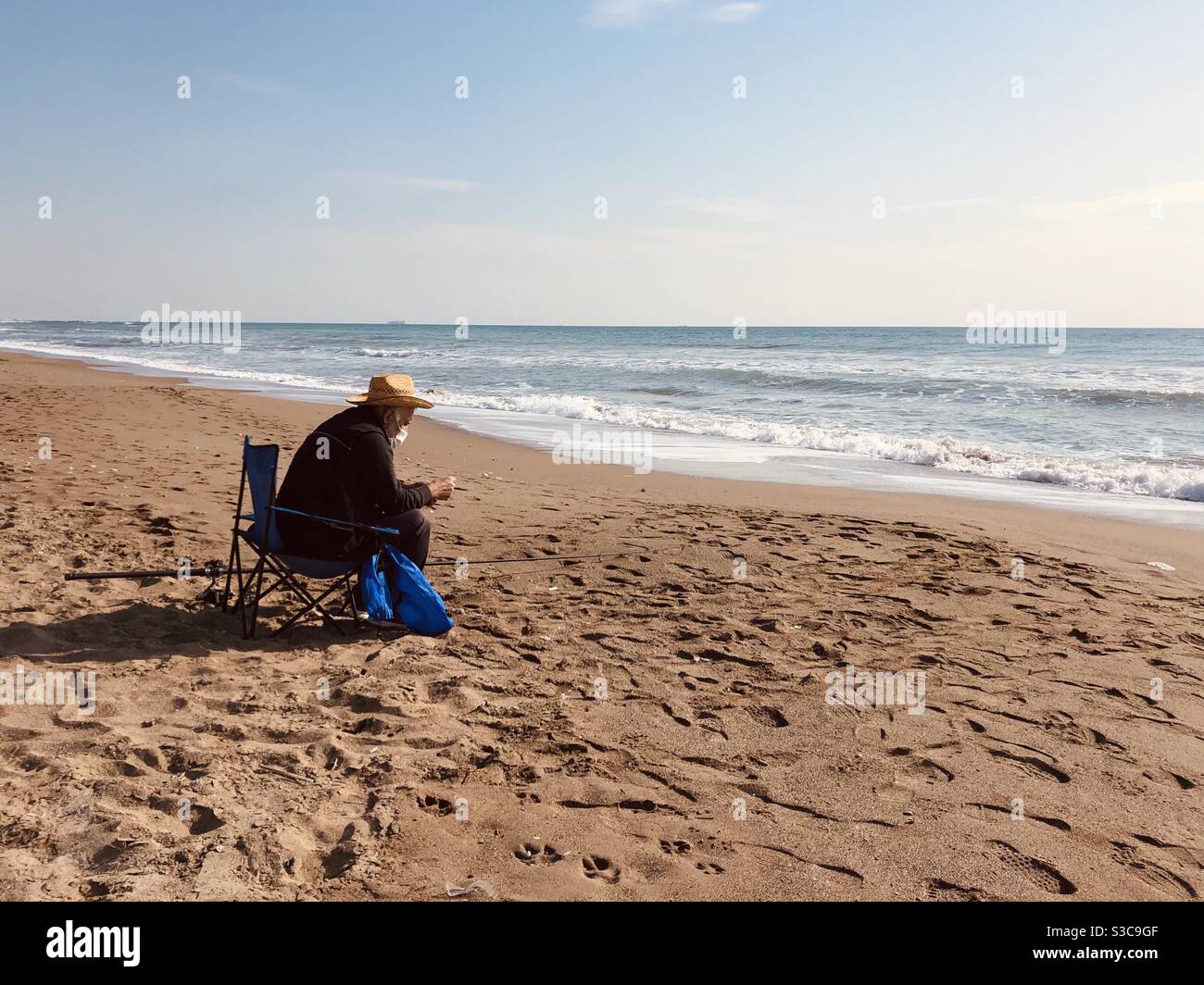 Mann mit Strohhut Angeln am Strand Stockfoto