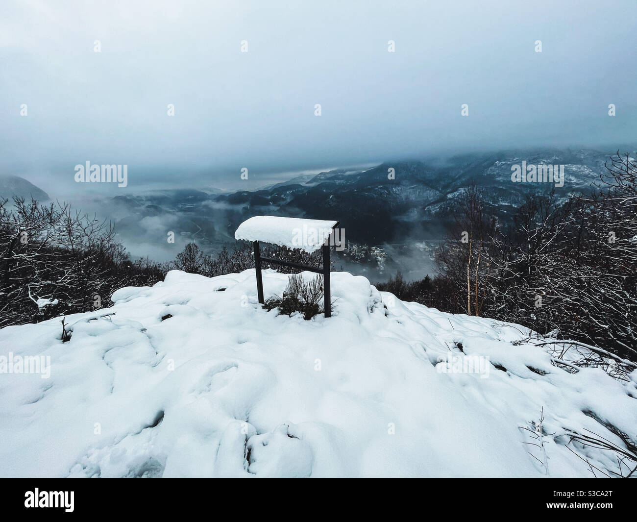 Schneebedecktes Dorf vom Berggipfel Stockfoto