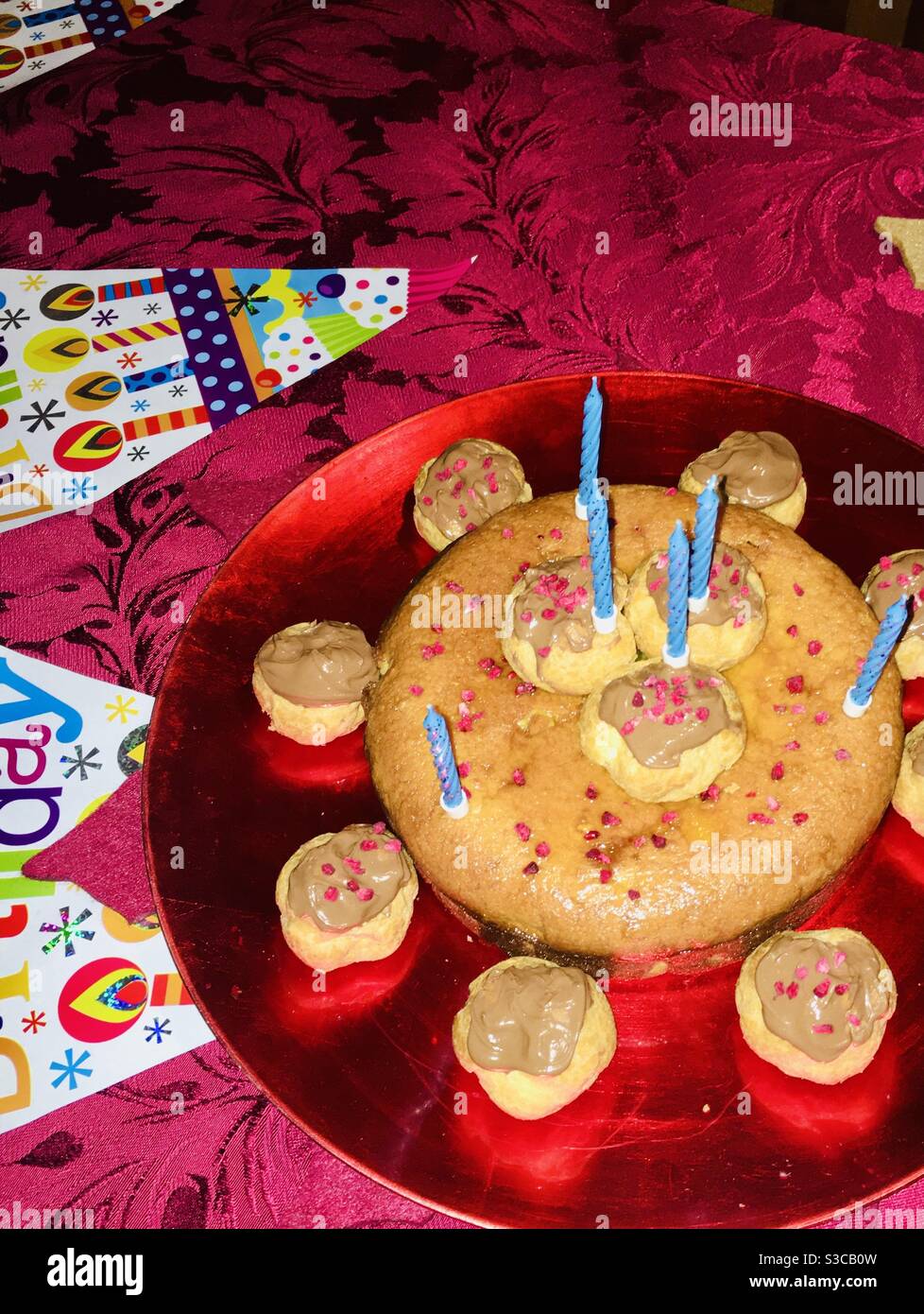 Geburtstagskuchen mit Profilöchern, blauen Kerzen und Happy Birthday Aging Stockfoto