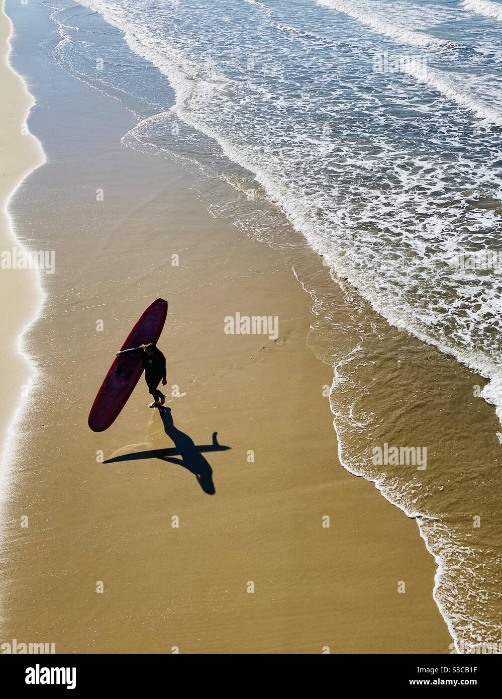 Eine Surferin geht von der Brandung aus. Manhattan Beach, Kalifornien, USA. Stockfoto