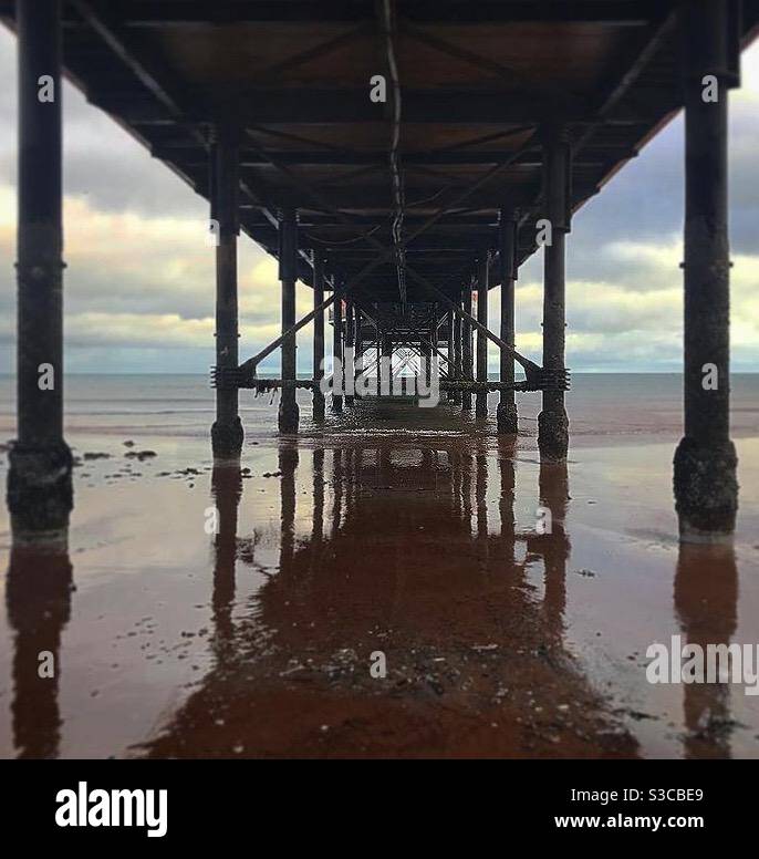 Symmetrische Aufnahme unter einem Pier am Strand Stockfoto